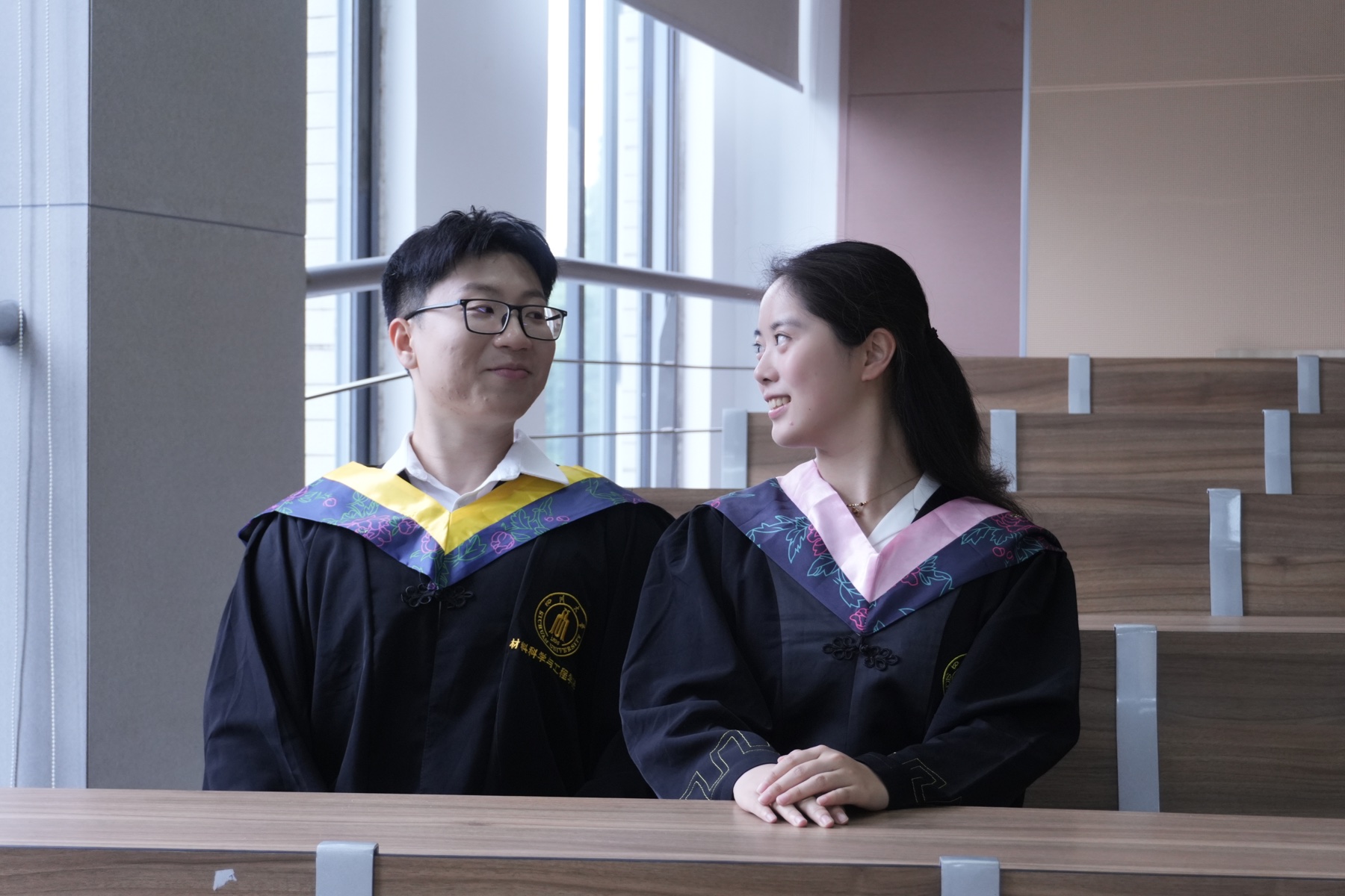 张桐宇和许琬苓穿学士服在教室相视