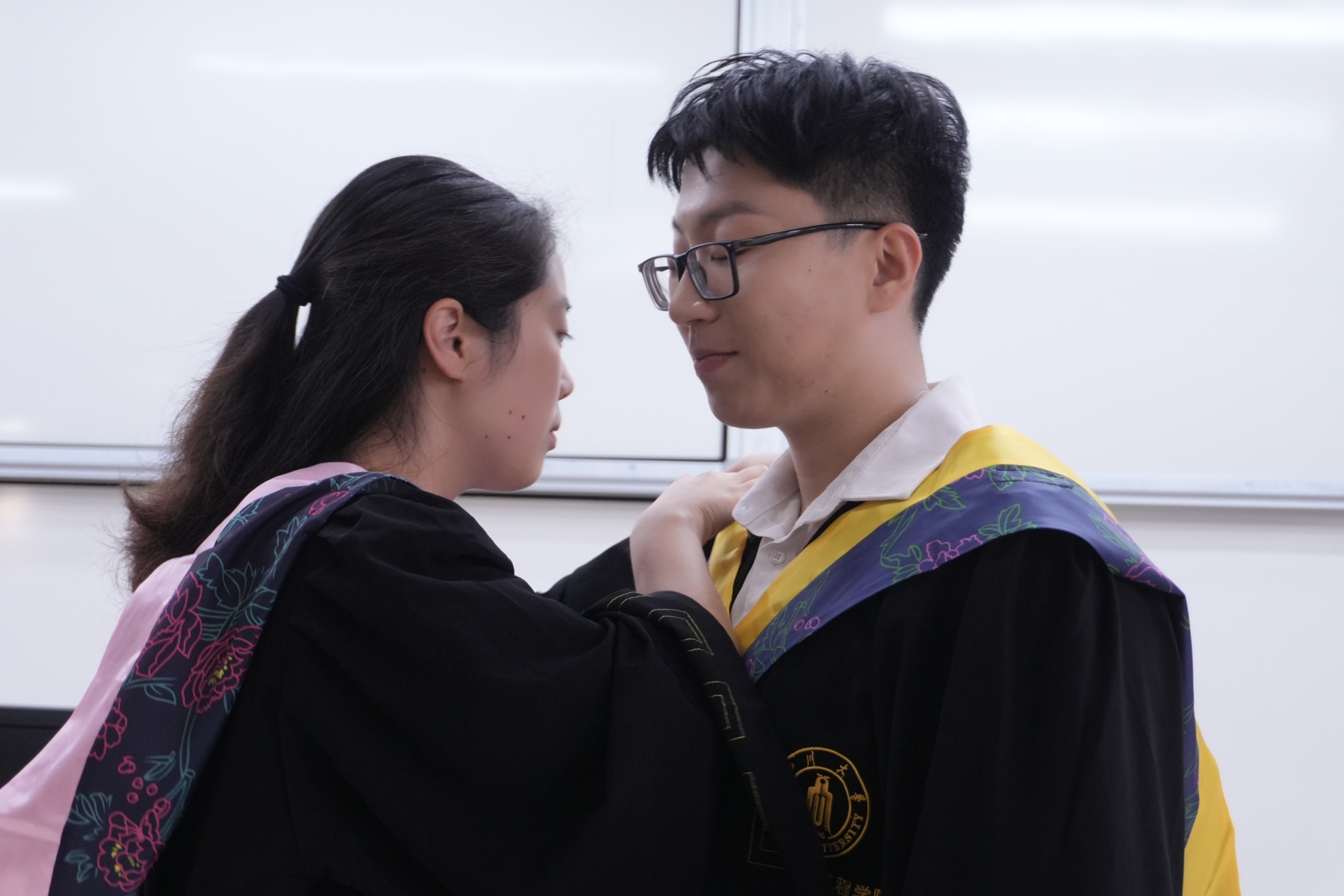 许琬苓帮张桐宇整理学士服衣领