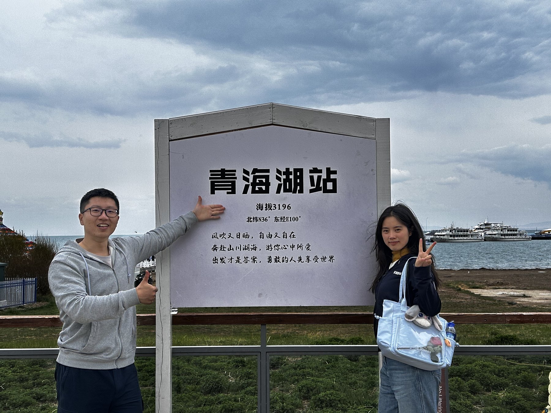 张桐宇和许琬苓站在青海湖站牌前合照